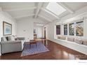 Open living room featuring hardwood floors, a skylight, and bright, white walls at 5266 Gallatin Pl, Boulder, CO 80303