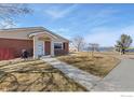 Quaint brick house with view of the lake, sidewalk to the front door and manicured lawn at 5425 County Road 32 # 13, Mead, CO 80504