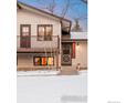 Close up of the front door with sidelight, porch, and snowy entry to the home at 5564 Colt Dr, Longmont, CO 80503