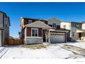 Exterior of the house featuring a two-car garage, stone accents, and a well-maintained front yard with snowy landscaping at 6121 Easton Cir, Frederick, CO 80504