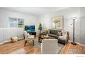 Cozy living room with hardwood floors, a modern TV setup, and natural light from the large window at 6343 E Ohio Ave, Denver, CO 80224