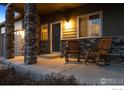 Inviting front porch with stone pillars and classic wooden rocking chairs at 684 Biscayne Ct, Berthoud, CO 80513