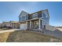 Beautiful two-story home with a covered porch, a two-car garage, and a well-maintained lawn at 7231 Clarke Dr, Frederick, CO 80530