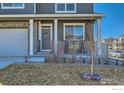 Inviting front porch with a swing, stone pillars, and a well-manicured lawn at 7231 Clarke Dr, Frederick, CO 80530