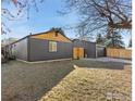 An exterior view of a modern gray home with wood accents and a detached garage showcasing its contemporary design at 1200 Martin Rd, Longmont, CO 80504