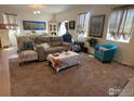 Inviting living room featuring neutral tones, comfortable seating, and natural light from large windows at 1431 Vantage Pkwy, Berthoud, CO 80513