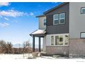 Stylish two-story home with a covered porch and attractive gray siding against a winter backdrop at 1525 E 3Rd Ave, Longmont, CO 80501