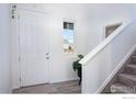 Bright entryway with white walls, wood-look flooring, and staircase leading to the upper level at 16722 Chilton Dr, Mead, CO 80542