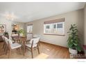 Comfortable dining room features hardwood floors, neutral walls, a large window, and chandelier at 1750 Little Bear Dr, Longmont, CO 80504