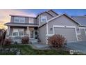 Attractive two-story home with a covered front porch and a three car garage with beautiful landscaping at 1931 Rannoch Dr, Longmont, CO 80504