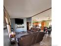 Open living room with wood floors, two brown leather couches, and a TV at 212 Skylark Cir, Lafayette, CO 80026