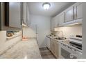 Galley kitchen with stone counters, tile floors, white appliances and cabinets at 3035 Oneal Pkwy # 36, Boulder, CO 80301