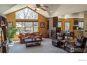 Bright living room featuring vaulted ceilings, stone fireplace, and access to the backyard at 3232 Mariner Ln, Longmont, CO 80503