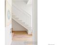 Modern staircase with wood treads, white risers and railings, and light wood floors in a white walled space at 3233 Tejon St # 101, Denver, CO 80211