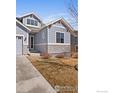 Charming two-story home featuring stone accents, gray siding, and well-maintained landscaping at 464 Wagon Bend Rd, Berthoud, CO 80513