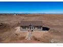 An aerial view of a tan single-story home in a rural setting, showcasing its location at 47705 Private Road 19 Rd, Elizabeth, CO 80107