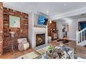 Warm living room featuring brick walls, fireplace, hardwood floors, and open access to the kitchen at 487 Pearl St, Boulder, CO 80302