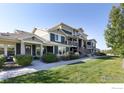 Attractive exterior view of townhome with green lawn and covered entrance at 543 Brennan Cir, Erie, CO 80516