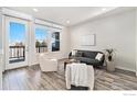 Bright living room with modern furniture, wood floors, and access to a balcony at 543 Brennan Cir, Erie, CO 80516