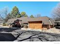 Exterior shot with a garage featuring a wooden door and well-maintained landscaping at 58 Curtis Ct, Broomfield, CO 80020