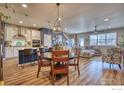 Open-concept living space with a kitchen island, dining area, and a comfortable living room at 651 Stonebridge Dr, Longmont, CO 80503