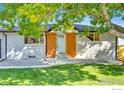 Charming front entrance with blue door, brick accent wall, and well-maintained landscaping at 7022 Quay St, Arvada, CO 80003