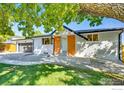 Beautifully landscaped front yard with a light blue front door and brick accents at 7022 Quay St, Arvada, CO 80003