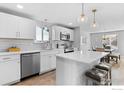 Modern kitchen with white cabinets, stainless steel appliances, and quartz countertops at 937 Meeker St, Longmont, CO 80504