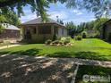 Well-maintained home boasts a lush green lawn and manicured landscaping in a peaceful neighborhood at 109 E Iowa Ave, Berthoud, CO 80513