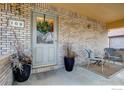 Charming brick porch with decorative potted plants and seating area at 109 E Iowa Ave, Berthoud, CO 80513