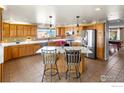 Bright kitchen with light wood cabinets, stainless steel appliances, and center island with bar seating at 11091 Wolff Way, Westminster, CO 80031