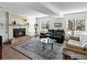 Inviting living room with a cozy fireplace, plush seating, and natural light from nearby windows at 11091 Wolff Way, Westminster, CO 80031