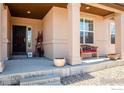 Inviting covered front porch with charming decor and a comfortable bench at 13328 King Lake Trl, Broomfield, CO 80020