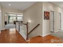 Elegant upstairs hallway with hardwood floors leading to a bright living area at 13328 King Lake Trl, Broomfield, CO 80020