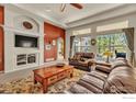 Cozy living room featuring a TV, fireplace, and large windows with natural light at 13328 King Lake Trl, Broomfield, CO 80020