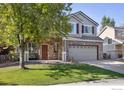 Inviting two-story home with a brick front, well-kept lawn, and a cozy front porch perfect for relaxing at 14828 E 118Th Pl, Commerce City, CO 80603