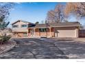 Charming two-story home with a brick facade, gray siding, attached garage, and a basketball hoop on the driveway at 15447 Huron St, Broomfield, CO 80023