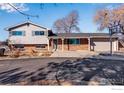 Charming two-story home with a brick facade, gray siding, attached garage, and a basketball hoop on the driveway at 15447 Huron St, Broomfield, CO 80023