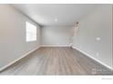 Open living room with light hardwood flooring, neutral walls, and bright natural light at 1854 Westport Ave, Berthoud, CO 80513