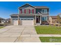 Inviting two-story home showcasing a three-car garage, well-manicured lawn, and charming curb appeal at 1884 Westport Ave, Berthoud, CO 80513