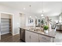 Modern kitchen with white cabinets, a gray countertop island, and stainless steel appliances and view to the living area at 1923 Westport Ave, Berthoud, CO 80513