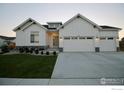 Beautiful two-story white farmhouse with a three car garage and manicured front yard at 205 Cowbell Dr, Berthoud, CO 80513