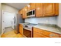 Well-lit kitchen with stainless steel appliances, tile backsplash, and wooden cabinets at 2238 Calais Dr # B, Longmont, CO 80504