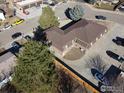 Aerial view of building with mature trees and landscaping, ample parking, and a fenced yard at 2241 Dexter Dr # 2, Longmont, CO 80501