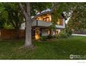 This is a backyard with green grass and a large tree with a balcony on the second story at 2545 Tamarack Ave, Boulder, CO 80304