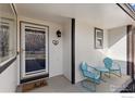 A cozy front porch featuring a decorative door, wall mounted light fixture, and seating for two at 2559 Serena Dr, Mead, CO 80542