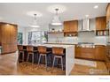 Bright kitchen with wood cabinets, stainless appliances, an island with seating, and a large window for natural light at 2575 Cragmoor Rd, Boulder, CO 80305