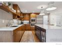 Beautiful kitchen featuring wooden cabinets, a large island with stone countertop, stainless steel appliances, and a stylish backsplash at 2575 Cragmoor Rd, Boulder, CO 80305