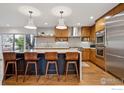 Bright kitchen with wood cabinets, stainless appliances, an island with seating, and a large window for natural light at 2575 Cragmoor Rd, Boulder, CO 80305