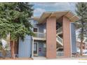 Multi-level blue condo with brick accents and an outdoor staircase is partially shaded by trees at 2800 Kalmia Ave # 320, Boulder, CO 80301
